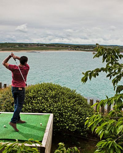 Guest practicing golf by the sea in Ardmore