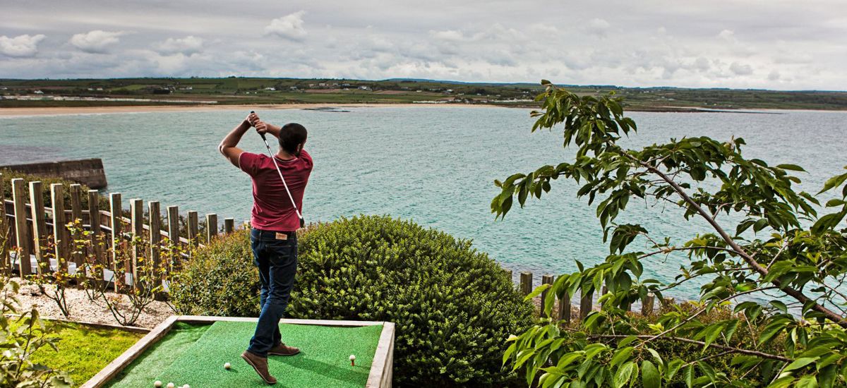 Guest practicing golf by the sea in Ardmore