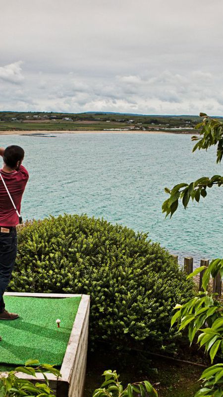 Guest practicing golf by the sea in Ardmore