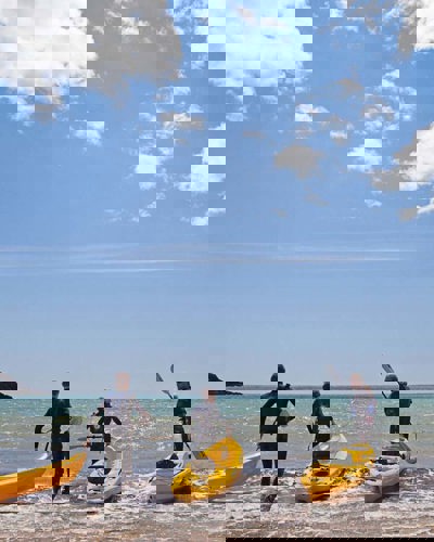 Guests launching kayaks from the beach in Ardmore