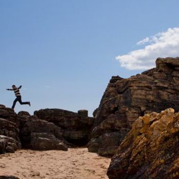 Child jumping on a sandy beach in Ardmore
