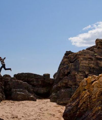 Child jumping on a sandy beach in Ardmore