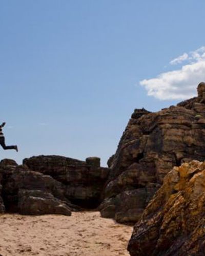 Child jumping on a sandy beach in Ardmore